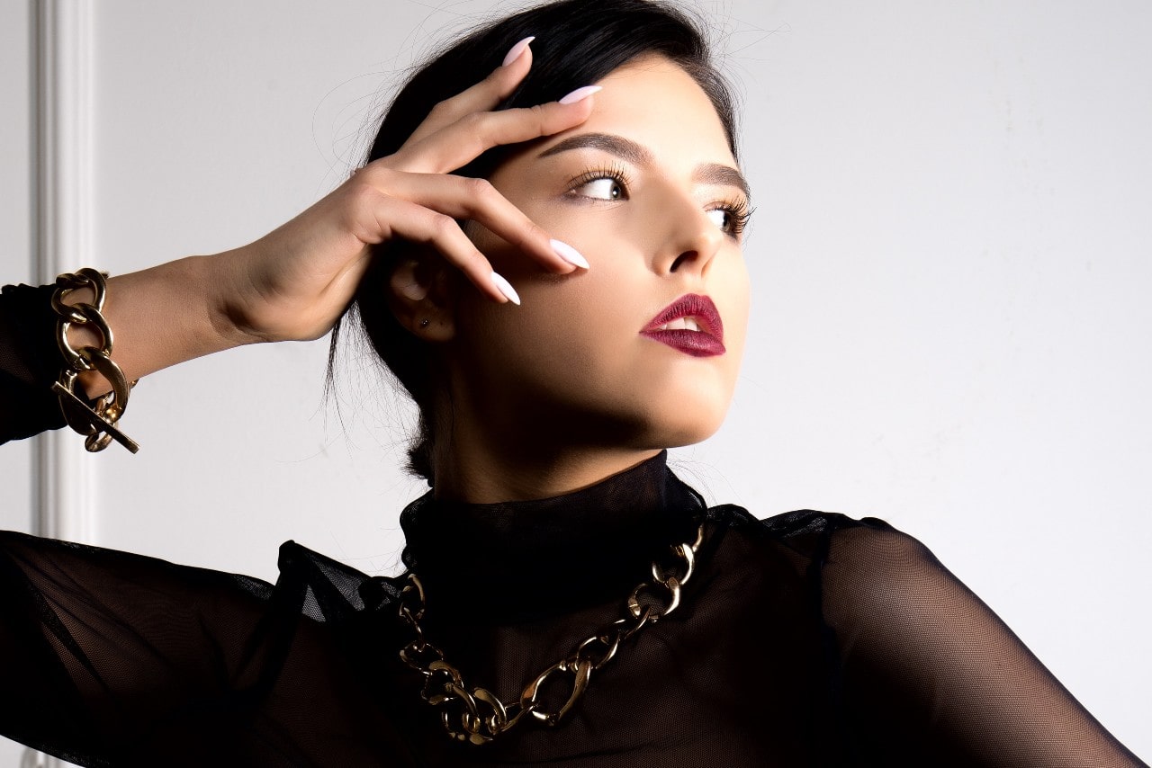 A woman wearing a matching oversized god chain necklace and bracelet