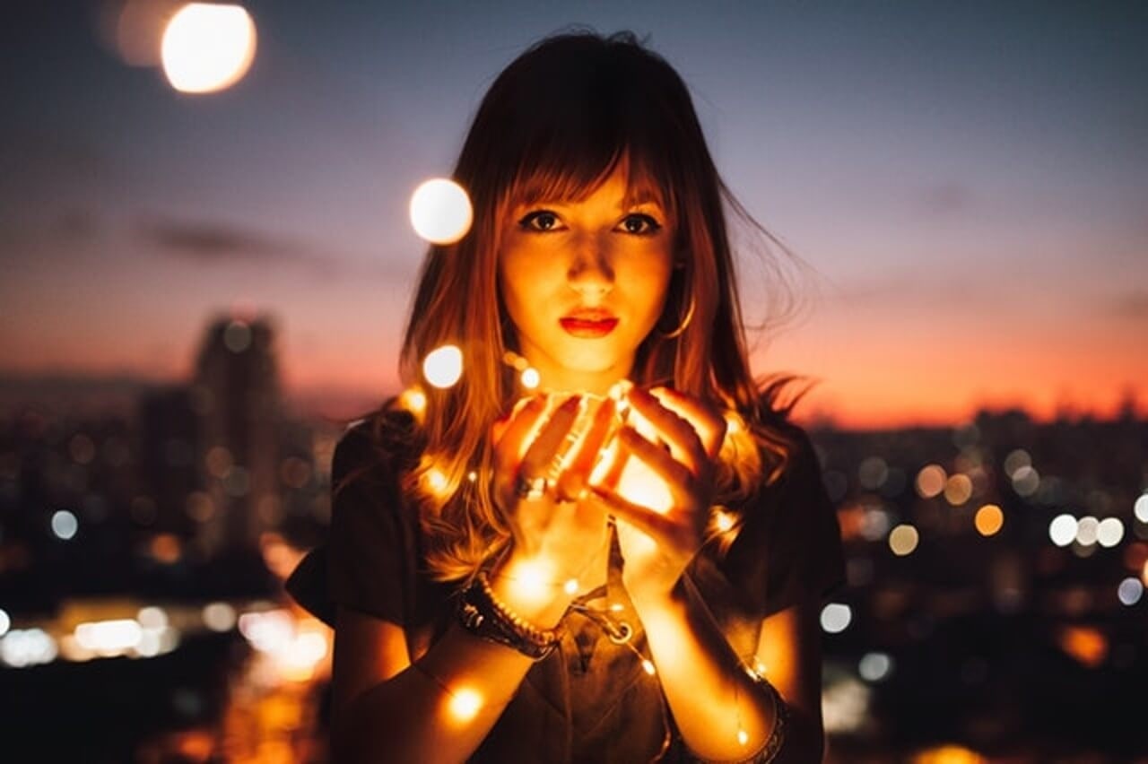 lady wearing fashion jewelry with festive lights in the background