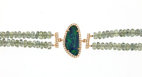 a bracelet featuring green beads and one large blue and green opal
