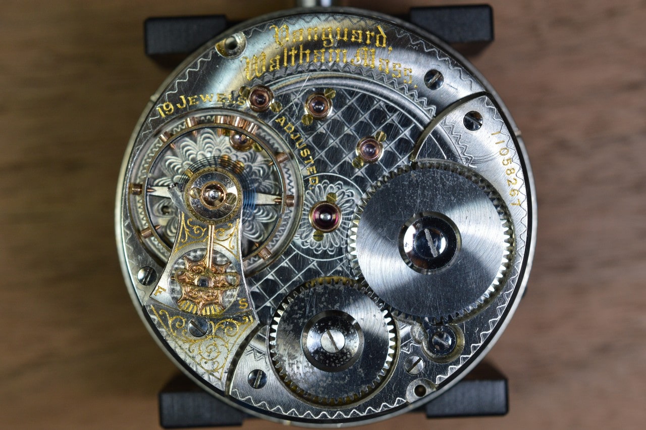 A close up of the inside of the various gears of a watch.