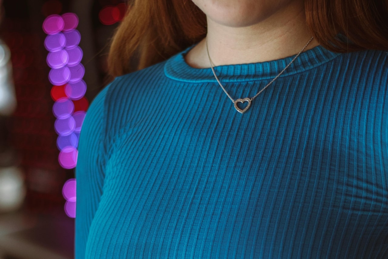 A woman wearing a heart shaped necklace on a Valentine’s Day date