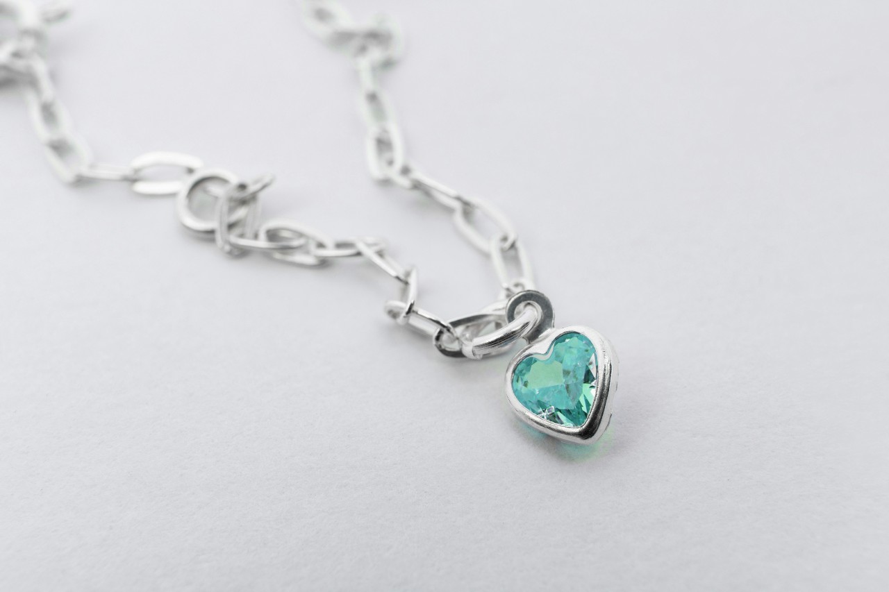 An aquamarine heart pendant on a white gold necklace with elongated links