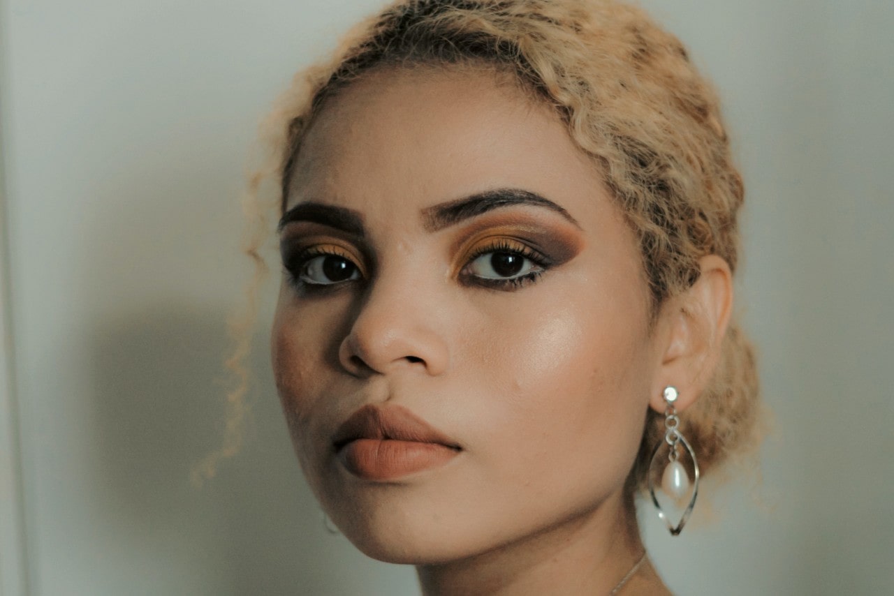 close up image of a woman wearing silver and pearl drop earrings close up image of a woman wearing silver and pearl drop earrings