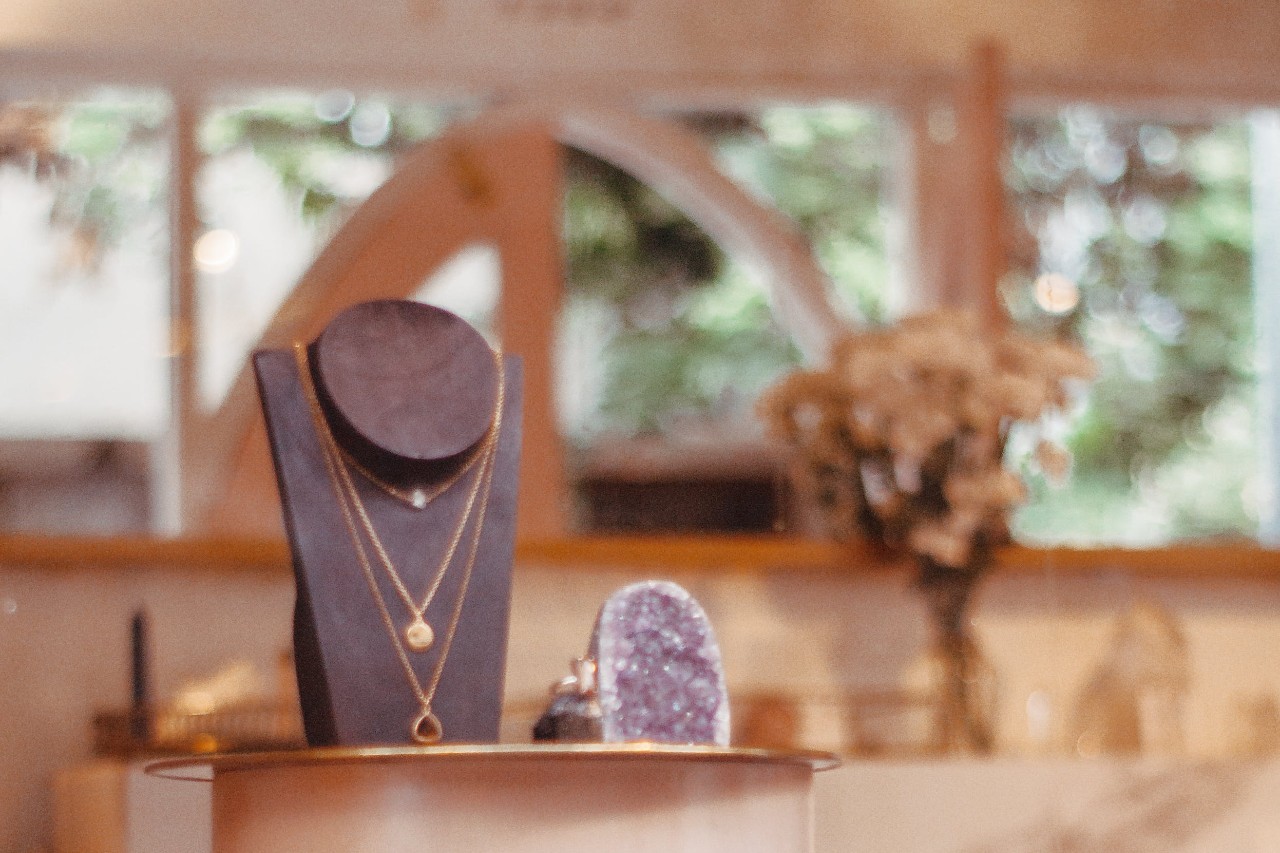 a fine jewelry display featuring layered necklaces in a jewelry store window