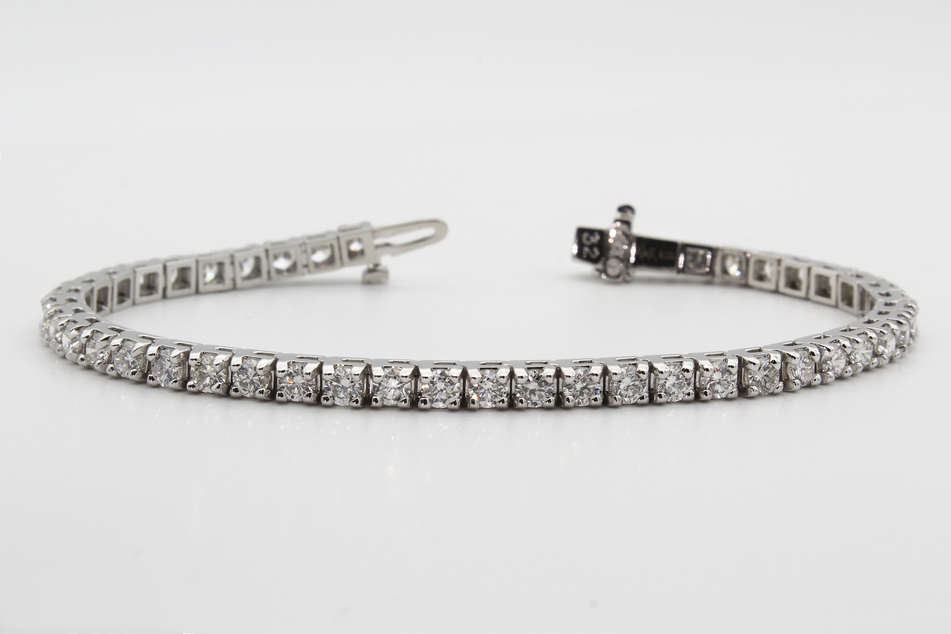 diamond and platinum tennis bracelet on a gray background