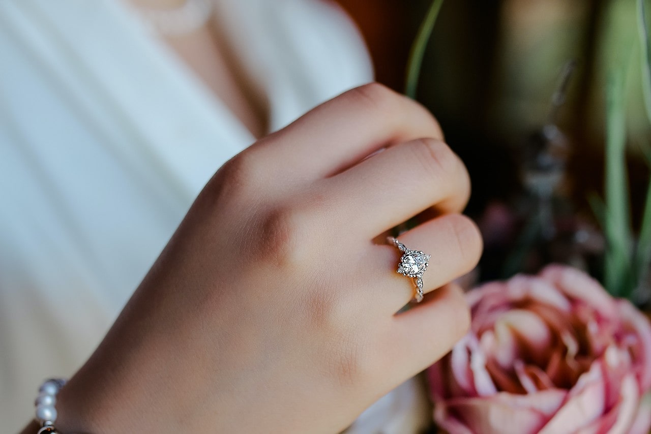 A close up of a bride’s platinum marquise cut engagement ring.