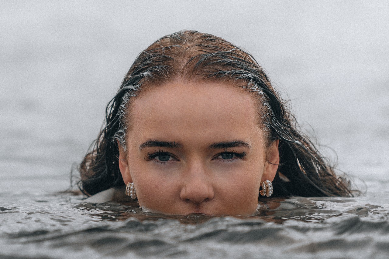 lady wearing earrings with her head sticking up from a body of water lady wearing earrings with her head sticking up from a body of water