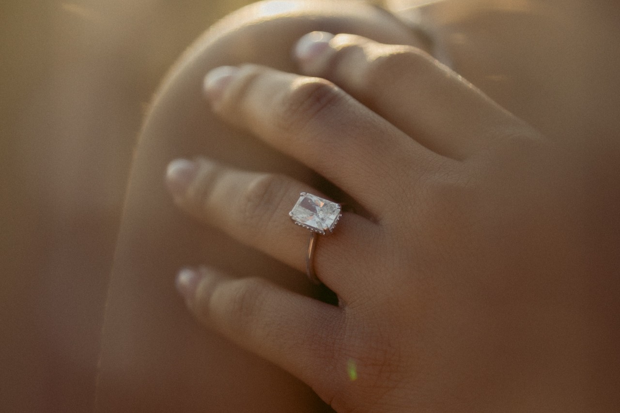 A close-up of a bride-to-be’s hand, adorned with a unique engagement ring. A close-up of a bride-to-be’s hand, adorned with a unique engagement ring.